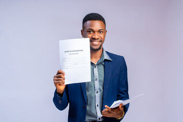 man isolated over white background holding a covid 19 vaccination form