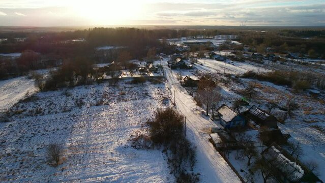 Country houses in the countryside in winter season. Aerial view of roofs in snow of rural homes. Village with wooden home. Suburban house at farm. Housing outside the city. Agriculture, farming 

