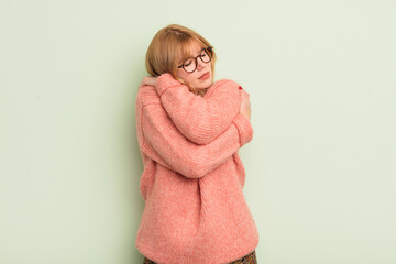 redhead pretty woman feeling in love, smiling, cuddling and hugging self, staying single, being...