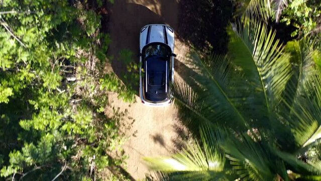 Lost White Car Driving On Remote Forest Dirt Road; Overhead Tracking Shot