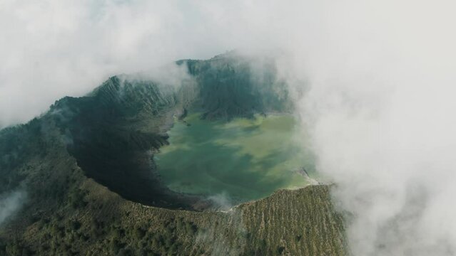 Aerial birds eye shot of vast El Chich&oacute;n Volcano with hovering clouds and acidic crater lake in sunlight,Mexico
