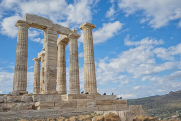 Close up view of Temple of Poseidon with blue sky and clouds, Sounion, Greece