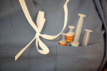 Syringes in shirt pocket of scrubs worn by nurse