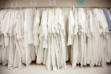 Lab coats on rack at pharmaceutical factory