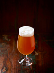 Glass of Wheat Beer on dark wooden background. Copy space. 