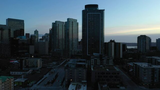 Rising aerial of Seattle's downtown skyscrapers at sunset.