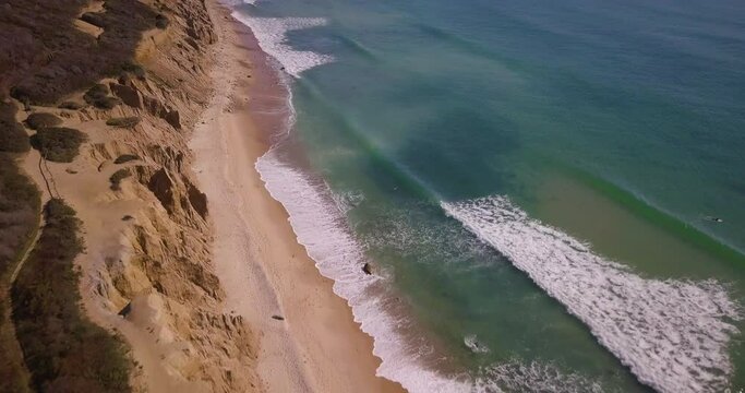 Gorgeous aerial view of waves rolling into shore along a beach in Montauk, East Hampton on Long Island.