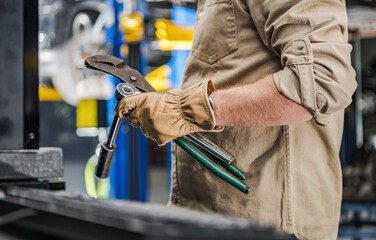 Automotive Industry Worker with Car Repairing Tools in His Hands