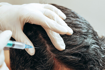 Cosmetologist performs anti-aging procedures injections hyaluronic acid into scalp, hair growth...