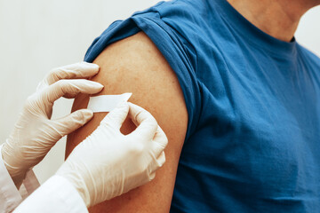 Nurse sticks patch on man after vaccination. The concept of worldwide vaccination against...