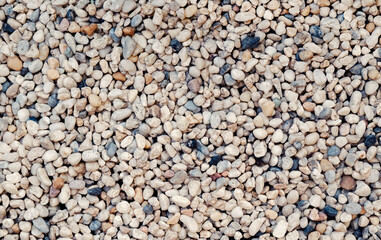 Natural background of small stones and pebbles on the ground for the garden decoration.