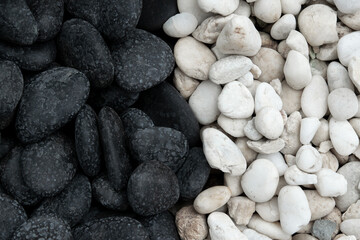 Natural background half of black and white stones in round shape on the ground for the garden decoration.