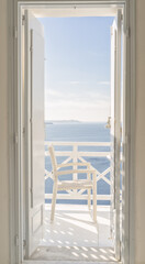 White deck and a patio chair, with ocean view in Santorini Greece