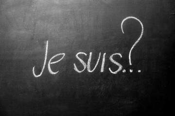 Inscription in French my name is. written je suis with chalk on blackboard