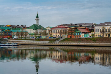Fototapeta na wymiar View of the embankment of Lake Nizhny Kaban, Shigabutdin Marjani Street with traditional Tatar mansions and Marjani Mosque on a spring day, Kazan, Republic of Tatarstan, Russia