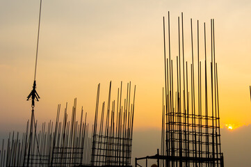 Steel reinforce in concrete column.Steel grid on the construction site.Reinforcement of concrete work. Using steel wire for securing steel bars with wire rod for reinforcement of concrete at sunset
