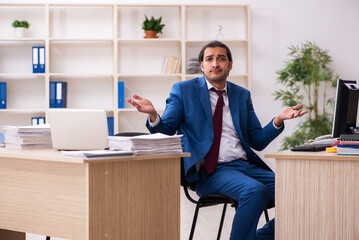 Young male employee in multitasking concept