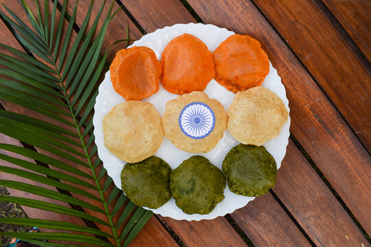 Tirange theme concept of three colours of Puri, Masala orange puri, plain white and Spinach with Ashokchakra. Republic and Independence day celebration eating serving food