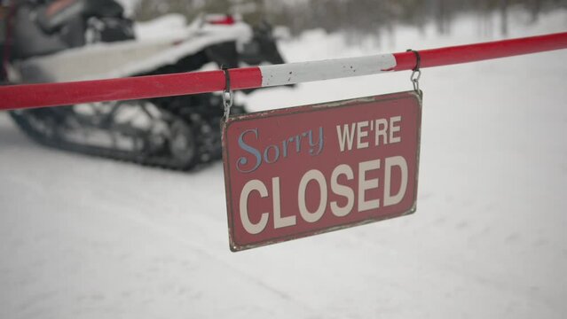 Closed sign in the snow with snowmobile in the Background
Wir haben geschlossen Schild im Schnee mit Schneescooter im Hintergrund