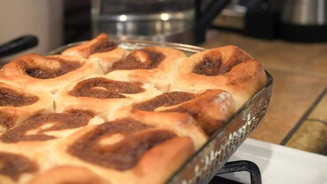 A pan of freshly baked cinnamon rolls hot out of the oven and still steaming with aromatic goodness 