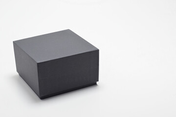 Caja negra cuadrada sobre fondo blanco, espacio para texto al lado derecho.