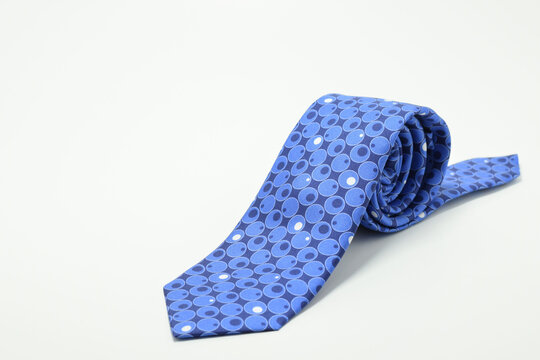 Corbata azul con diseño sobre fondo blanco. Espacio para texto al lado izquierdo.