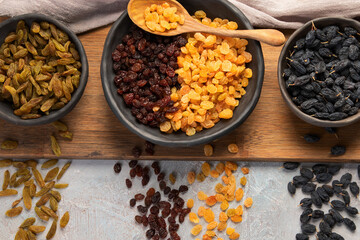 Different types of raisins on light backgroound.