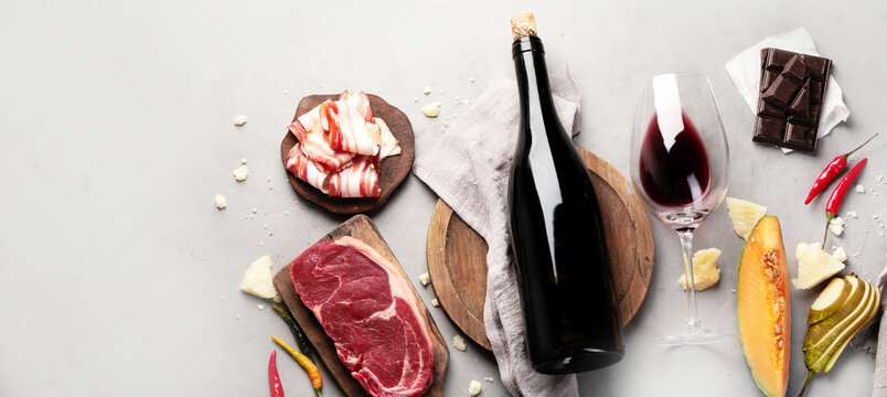 Red wine Primitivo with appetizers on gray background.