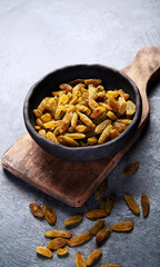 Green raisins on dark background.