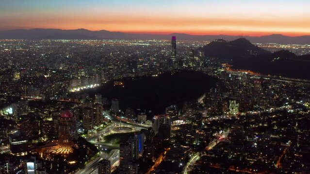 Night Time Aerial View Over Santiago City In Chile With Orange Sunset Skies