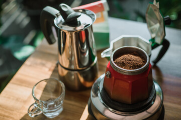 Finely ground coffee and vintage coffee maker moka pot on wooden table at home ,Selective focus.