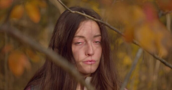 Close up gimbal shot of woman face among autumn landscape. Slomo