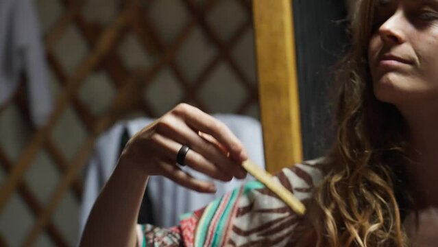 Beautiful woman in an ecovillage commune burns incense in a meditation ceremony