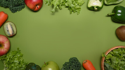 Fresh assorted fruits and  vegetables on green background. Healthy food concept.