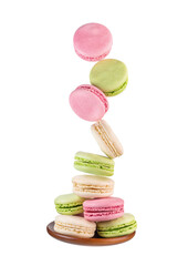 Macaroons in motion falling on a wooden plate isolated on white background.