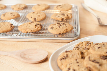 Chocolate chip cookies on a cooling rack on wooden kitchen counter