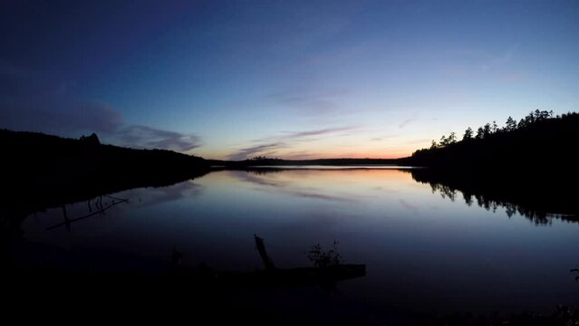 Sunset time lapse of calm backcountry boreal shield lake in Northern Ontario Canada