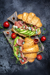 Variety of aperitifs Croissant sandwiches with jamon ham serrano paleta iberica, blue cheese,...