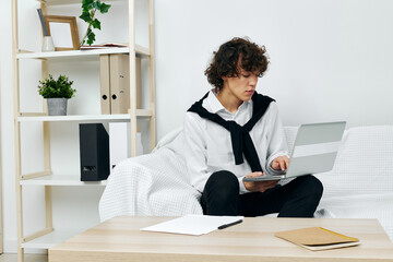 guy on a white sofa in front of a laptop learning living room