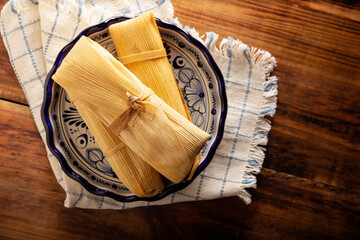 Tamales. Prehispanic dish typical of Mexico and some Latin American countries. Corn dough wrapped in corn leaves. The tamales are steamed. - 482531897