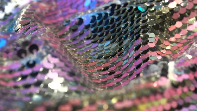 Fabric for a festive dress with pink, purple and silver sequins. Textile background for a romantic holiday