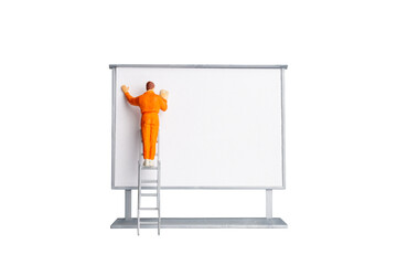Miniature people Painter holding a brush at The front of a whiteboard isolated on white background...