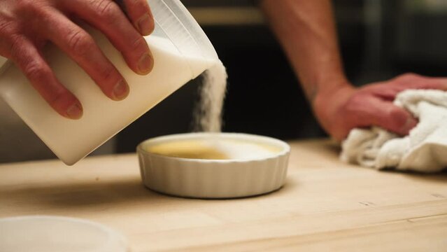 Sugar being poured onto cr&egrave;me brulee by chef slow motion 4k 30p