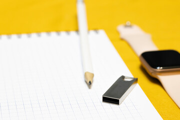 Pencil on a white sheet of paper, next to a smart watch and a flash drive. Modern new devices, gadgets.