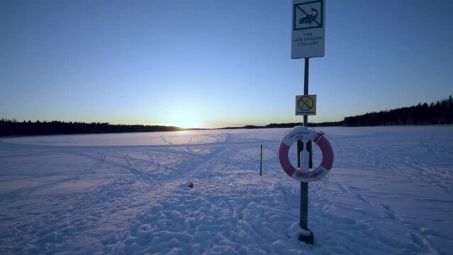 Frozen lake with a snow-covered lifebelt