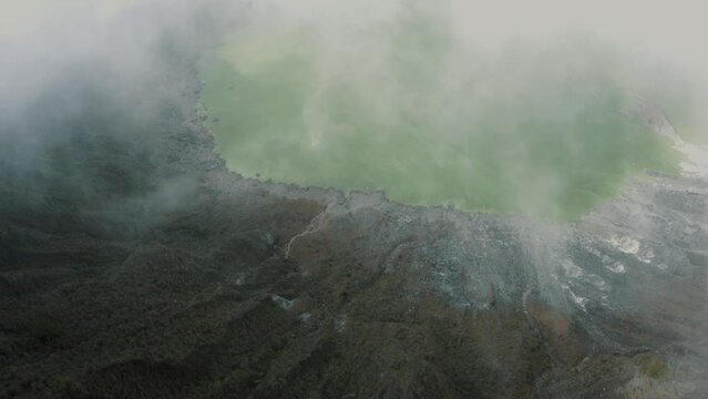 Aerial flight into El Chichon Volcano towards acidic crater lake through dense steam
