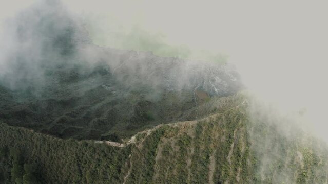 Dense Clouds hiding massive active Volcano with lake in valley during sun - Chichonal,Francisco Leon,Mexico