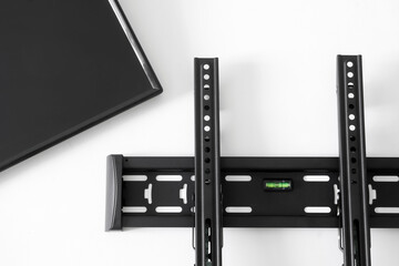Black metal bracket for wall mounting TV and monitor screen on white background. Concept of...