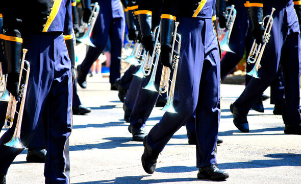 Marching band in a parade outdoors.