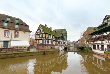 view of medieval buildings reflection on the channel at little france quarter in Strasbourg by winter
